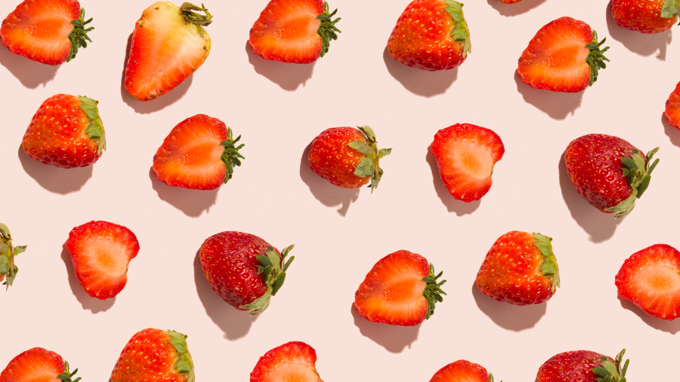 Strawberries in rows with a pink background